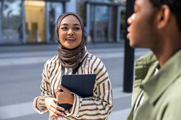Happy diverse professionals discussing outside office
