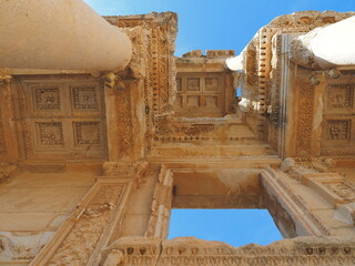 A close-up view of the intricate stonework of the Ephesus ruins in Turkey, with a column in the...