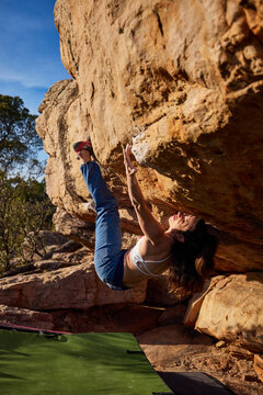 Female climber hanging on rocky cliff