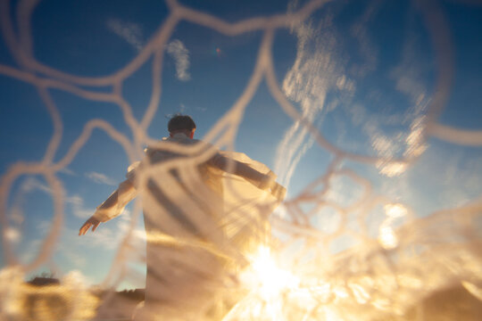 A woman in the white dress dancing in the sunlight 