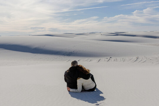 A couple admires the dunes in the desert