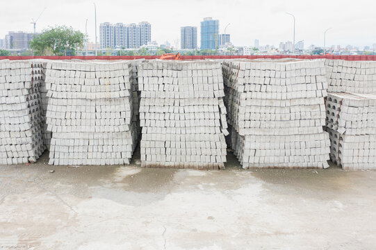 Stacked Concrete Bricks on a Construction Site with City View