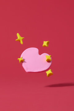 Pink clay hearts on red background, minimal Valentine's Day decoration