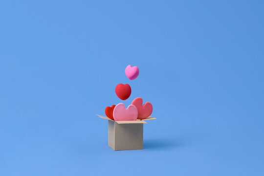 Hearts fly around cardboard on blue background