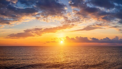 Obraz premium sunset sky clouds over sea in the evening with orange yellow sunlight horizon sea landscape background and sun down in golden hour summer season dusk