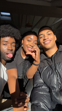 Diverse group of friends happily pose to take a group selfie