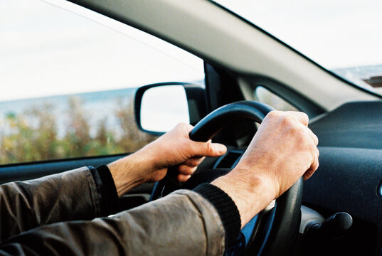 Film photo of man holding a steering wheel of a car