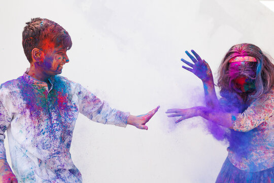 Brother and sister playing holi together with color powder