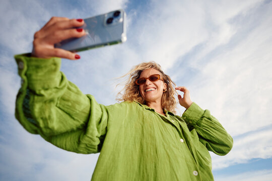 Pleased woman takes self-photo outdoors