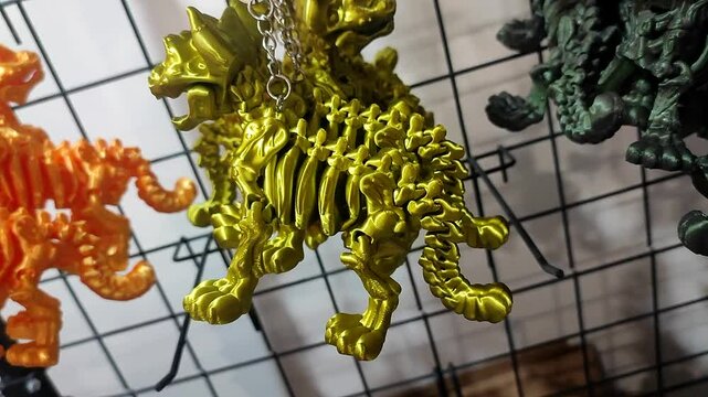 Objects keychains in form of dog skeleton models of toys printed on 3D printer from multi-colored molten plastic hanging on chain. Concept 3D Printing. New modern 3D Printing additive technology