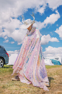 Person in sequin costume with antlered hat at outdoor festival