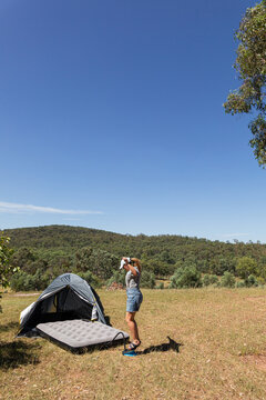 Woman Setting Up Tent with Air Mattress Outside in Australia