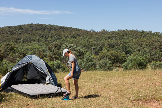 Woman Preparing for Camping Trip with Air Mattress