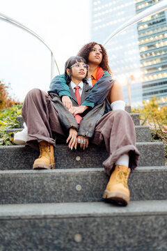Two young women sitting on stairs wearing retro fashion