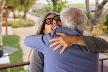 Emotional reunion as elderly pair embrace outdoors in joy