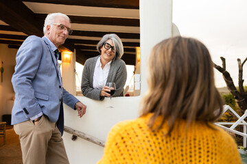 Senior couple engaging with woman during relaxing outdoor conversation
