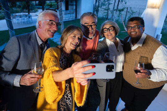 Happy senior friends taking a selfie at an evening celebration