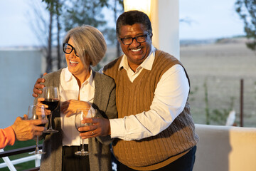 Happy senior couple enjoying a drink at an outdoor gathering