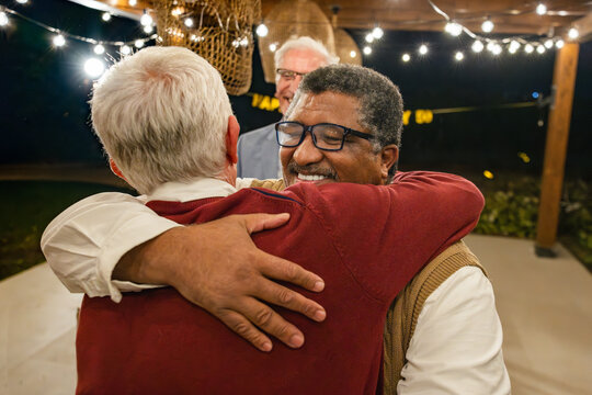 Heartfelt Reunion of Friends at an Outdoor Evening Gathering