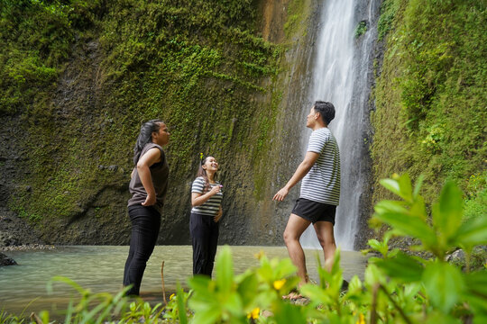 small group of happy asian Indonesian man and woman chit chat around curug sidoharjo or sidoharjo waterfall