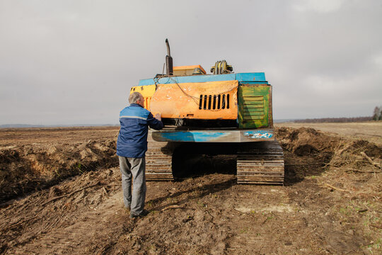 A worker opens the lid on an excavator.