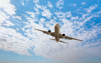 White passenger airplane flying in the sky amazing clouds in the background - Travel by air transport
