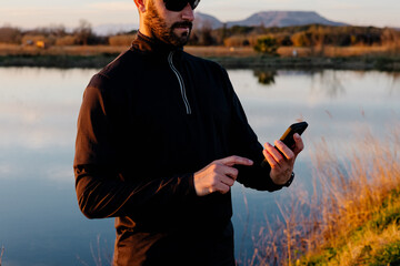 A fit man reviewing his performance metrics on a smartphone