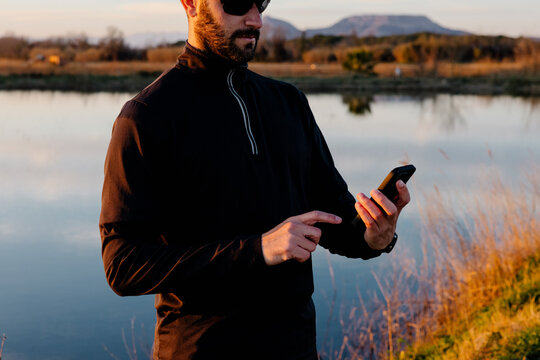 A fit man reviewing his performance metrics on a smartphone