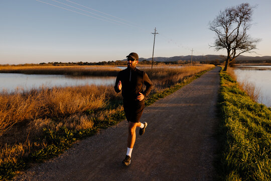 Sporty adult improves his physical condition by running outdoors