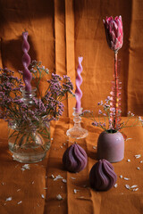 candle composition with flowers and natural textiles, pink color