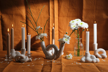 candle composition with flowers and natural textiles