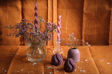 candle composition with flowers and natural textiles