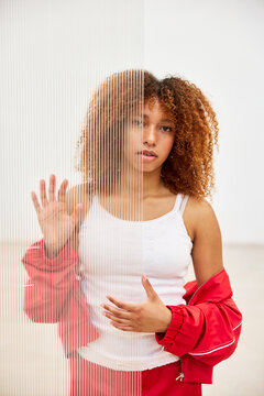 Black woman in sportswear behind plexiglass