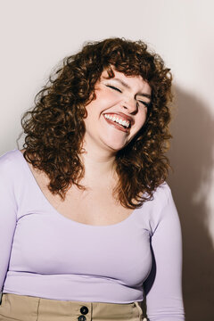 Cheerful woman with curly hair and joyful expression