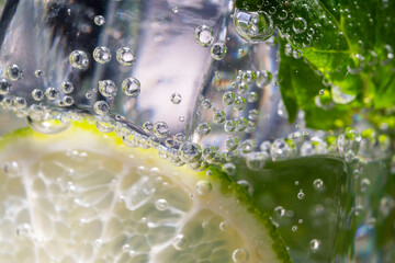 Mojito alcoholic cocktail, rum with mint ice, lime and tonic, close-up, macro