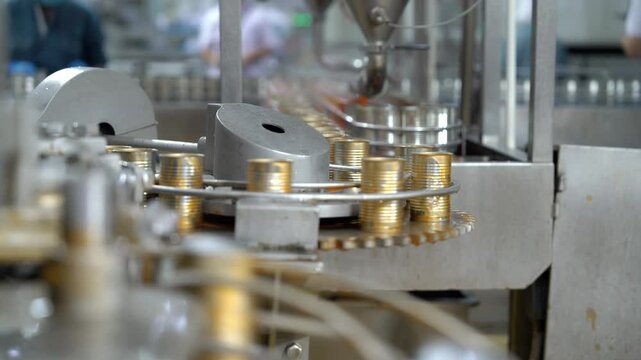 Automatic production line is filling canned ketchup Food factory industry production plant.