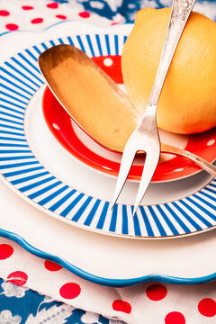 Bright table setting with plates and lemon on patterned cloth
