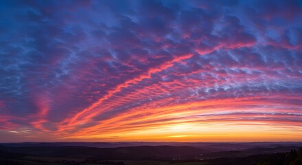 Fototapeta premium Espectacular puesta de sol con nubes vibrantes sobre un paisaje espectacular: cielo impresionante