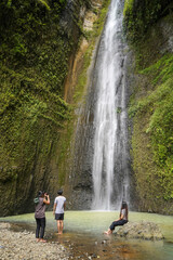 small group of happy young asian people exploring waterfall