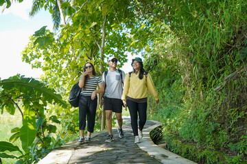 group of happy young asian indonesian people walking together on the walk path in the park