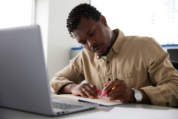 Serious businessman using marker at desk in office