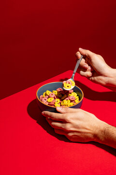 Anonymous person eating colorful cereals