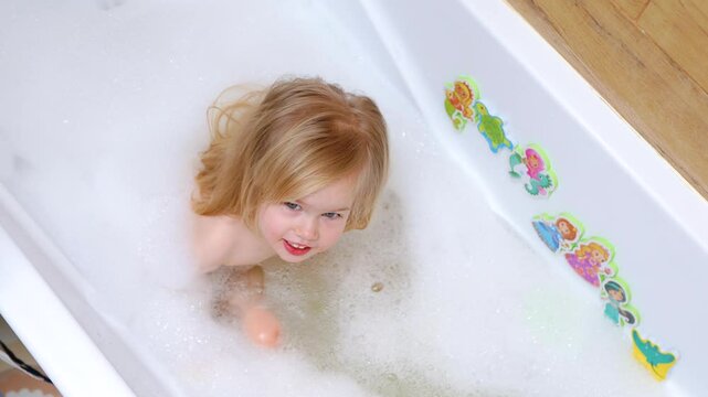 Little child girl caucasian bathing in a bubble bath