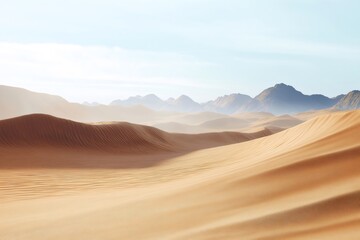Naklejka premium Sand dunes covering an endless desert landscape with mountains visible in the distance under a clear sky
