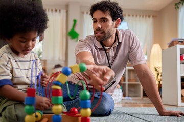 Daycare worker showing toy to toddler