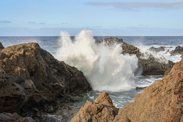 Waves crashing against volcanic rocks........