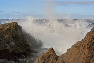 Waves crashing against volcanic rocks........