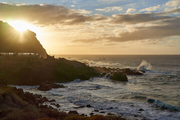 Obraz premium Golden sunset over a rugged volcanic coastline........