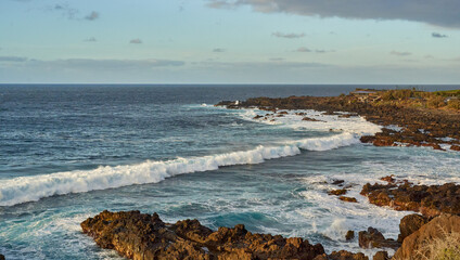 Waves crashing on volcanic shore