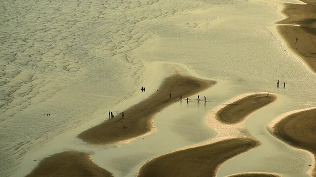People walking on sandbanks at low tide  
